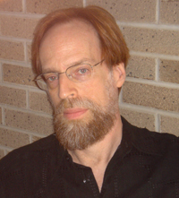 This is a photo of Lev Raphael. He is wearing glasses, a beard, and a dark shirt.